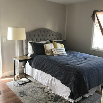 Beige colored walls with gray upholstered headboard
