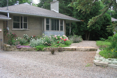 Design ideas for a mid-sized transitional drought-tolerant and full sun front yard gravel landscaping in Montreal.