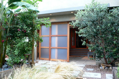 Small coastal green two-story stucco exterior home idea in Los Angeles