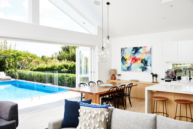 Photo of a contemporary open plan dining in Sydney with white walls and light hardwood floors.