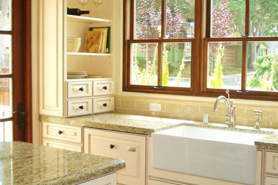 Inspiration for a cottage open concept kitchen remodel in San Francisco with a farmhouse sink, raised-panel cabinets, granite countertops, beige backsplash, porcelain backsplash, stainless steel appliances and an island