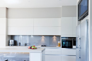 Inspiration for a large contemporary galley eat-in kitchen in Other with an undermount sink, white cabinets, quartz benchtops, grey splashback, glass sheet splashback, stainless steel appliances, dark hardwood floors and with island.