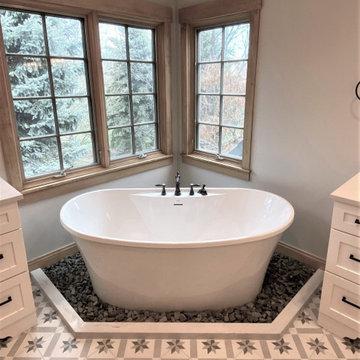 Freestanding tub surrounded by river rocks