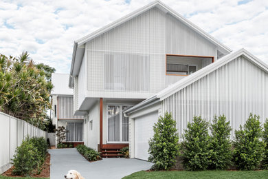 Beach style two-storey white duplex exterior in Other with metal siding and a gable roof.