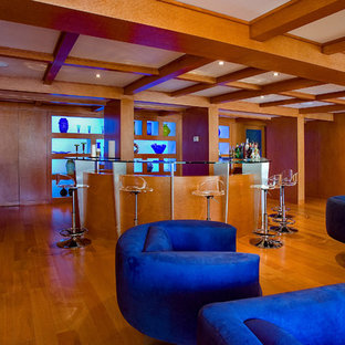 他の地域の中サイズのトランジショナルスタイルのおしゃれな着席型バー (アンダーカウンターシンク、フラットパネル扉のキャビネット、茶色いキャビネット、ガラスカウンター、淡色無垢フローリング、茶色い床) の写真