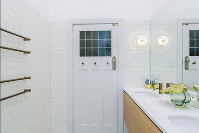 This is an example of a small contemporary 3/4 bathroom in Adelaide with white tile, ceramic tile, white walls, porcelain floors, grey floor, furniture-like cabinets, medium wood cabinets, quartzite benchtops and white benchtops.