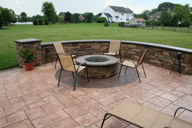 This is an example of a traditional backyard patio in New York with stamped concrete.