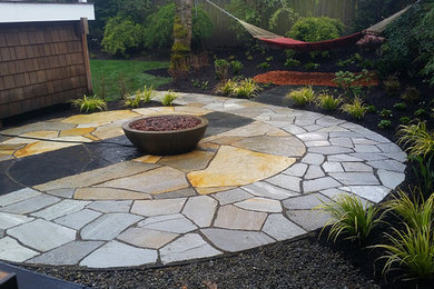 Design ideas for a large eclectic backyard patio in Seattle with a fire feature, natural stone pavers and no cover.