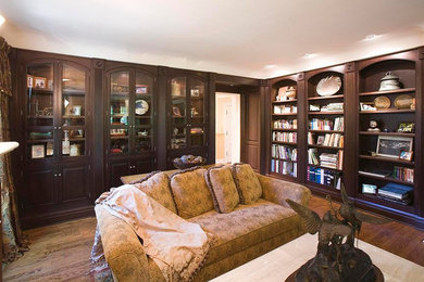 Example of a large classic enclosed medium tone wood floor and brown floor living room library design in Chicago with beige walls
