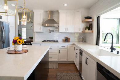Inspiration for a large contemporary u-shaped medium tone wood floor and brown floor kitchen pantry remodel in Los Angeles with an undermount sink, shaker cabinets, white cabinets, quartz countertops, white backsplash, porcelain backsplash, stainless steel appliances, an island and white countertops