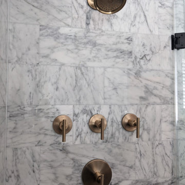 Modern primary bathroom with marble tile, curbless shower and custom vanity