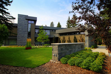 Photo of a large modern partial sun courtyard mulch formal garden in Edmonton.