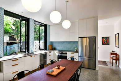 Design ideas for a contemporary l-shaped eat-in kitchen in Brisbane with an undermount sink, white cabinets, quartz benchtops, blue splashback, ceramic splashback, stainless steel appliances, concrete floors, no island, grey floor and grey benchtop.