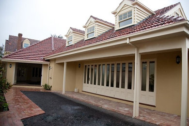 Inspiration for a mid-sized traditional side yard verandah in Sydney with brick pavers and a roof extension.