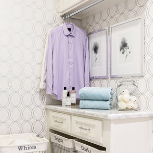 ヒューストンの小さいトランジショナルスタイルのおしゃれなランドリールーム (白いキャビネット、木材カウンター、磁器タイルの床、白い床、白い壁、左右配置の洗濯機・乾燥機、落し込みパネル扉のキャビネット) の写真