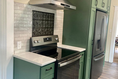Inspiration for a mid-sized modern laminate floor and brown floor enclosed kitchen remodel in Portland with an undermount sink, shaker cabinets, green cabinets, quartz countertops, gray backsplash, ceramic backsplash, stainless steel appliances, no island and white countertops