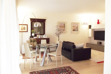 Ejemplo de salón cerrado de tamaño medio con paredes blancas, suelo de madera clara, televisor colgado en la pared y suelo beige