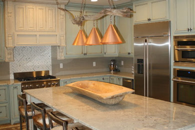 Large mountain style u-shaped light wood floor eat-in kitchen photo in Other with a farmhouse sink, raised-panel cabinets, green cabinets, granite countertops, gray backsplash, ceramic backsplash, stainless steel appliances and an island