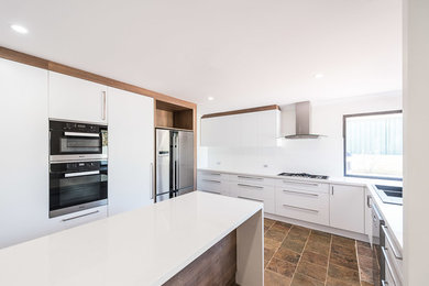 Photo of a large contemporary u-shaped kitchen in Perth with an undermount sink, flat-panel cabinets, medium wood cabinets, quartz benchtops, white splashback, porcelain splashback, stainless steel appliances, slate floors and with island.