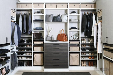 Inspiration for a large gender-neutral light wood floor walk-in closet remodel in Other with open cabinets and dark wood cabinets