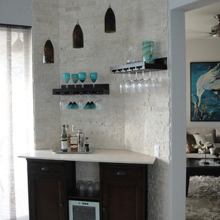 マイアミの小さいビーチスタイルのおしゃれなホームバー (シンクなし、落し込みパネル扉のキャビネット、黒いキャビネット、ライムストーンカウンター、白いキッチンパネル、レンガのキッチンパネル、セラミックタイルの床) の写真