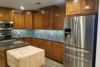 Example of a mid-sized transitional u-shaped porcelain tile and brown floor kitchen design in Other with an undermount sink, raised-panel cabinets, medium tone wood cabinets, granite countertops, multicolored backsplash, matchstick tile backsplash, stainless steel appliances and an island