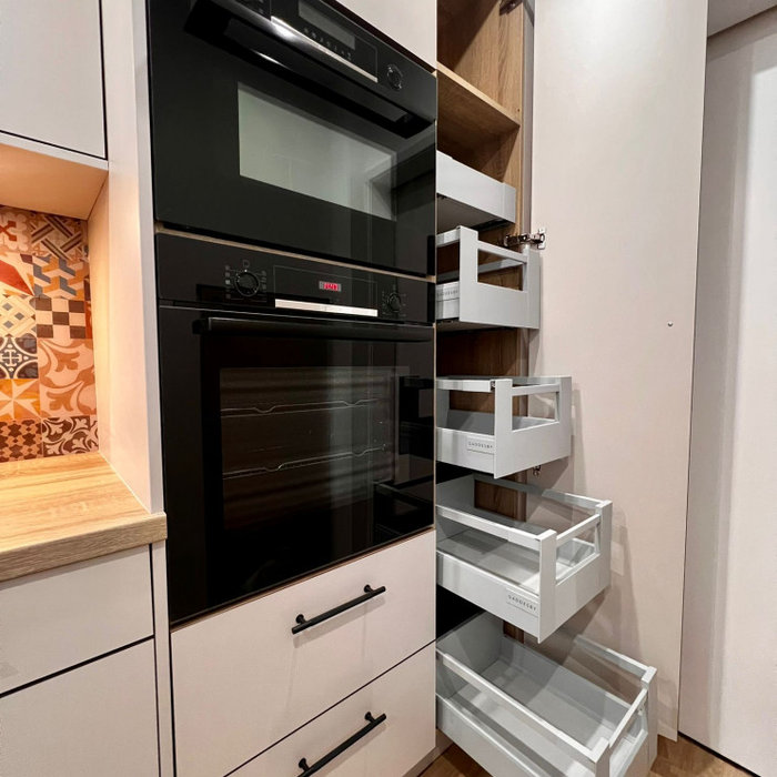 Example of a mid-sized trendy galley vinyl floor and brown floor enclosed kitchen design in Other with flat-panel cabinets, distressed cabinets, laminate countertops, multicolored backsplash, glass sh