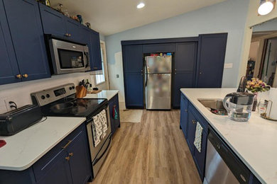 Ejemplo de cocina contemporánea grande con armarios estilo shaker, puertas de armario azules, encimera de cuarzo compacto, salpicadero de azulejos tipo metro y una isla