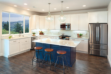 Inspiration for a mid-sized country l-shaped eat-in kitchen in Sacramento with an undermount sink, shaker cabinets, white cabinets, granite benchtops, white splashback, porcelain splashback, stainless steel appliances, dark hardwood floors, with island, brown floor and white benchtop.