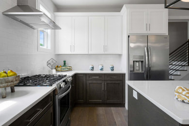 Mid-sized transitional open concept kitchen photo in Charlotte with shaker cabinets, quartz countertops, white backsplash, porcelain backsplash, stainless steel appliances, an island and white countertops