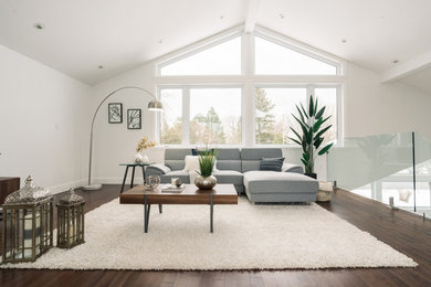 Example of a huge minimalist formal and open concept dark wood floor, brown floor and vaulted ceiling living room design in Montreal with white walls and a tv stand