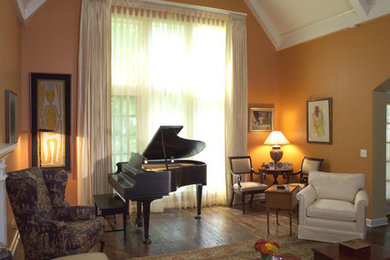 Inspiration for a mid-sized timeless formal and enclosed dark wood floor and brown floor living room remodel in San Diego with orange walls, a standard fireplace, a plaster fireplace and no tv