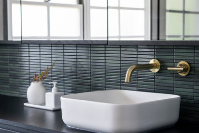 Inspiration for a large contemporary bathroom in Melbourne with black cabinets, a single vanity, a floating vanity, beaded inset cabinets, a freestanding tub, an open shower, a bidet, green tile, mosaic tile, grey walls, porcelain floors, a trough sink, laminate benchtops, grey floor, an open shower and black benchtops.