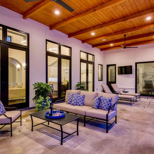 This is an example of a large mediterranean backyard patio in Austin with a water feature, stamped concrete and a roof extension.