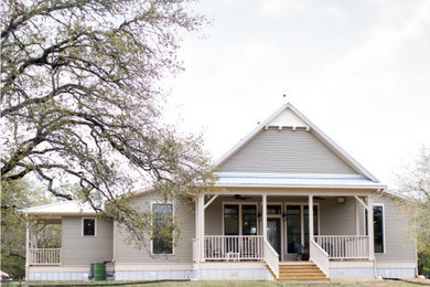 Inspiration for a farmhouse gray one-story concrete fiberboard exterior home remodel in Houston with a metal roof