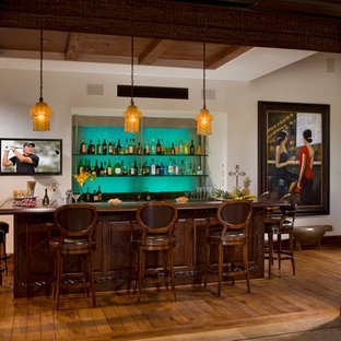 オレンジカウンティの地中海スタイルのおしゃれな着席型バー (無垢フローリング、濃色木目調キャビネット、木材カウンター、青いキッチンパネル、茶色い床、茶色いキッチンカウンター) の写真