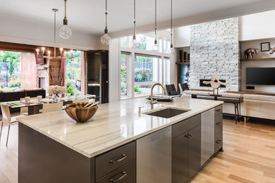 Photo of a large modern l-shaped open plan kitchen in Philadelphia with an undermount sink, flat-panel cabinets, white cabinets, white splashback, mosaic tile splashback, stainless steel appliances, light hardwood floors, with island, brown floor and quartzite benchtops.