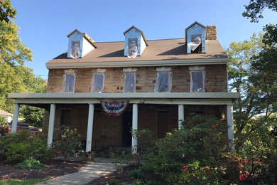 Example of a large classic beige brick exterior home design in Other with a shingle roof