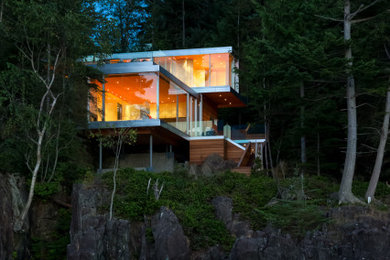 Inspiration for a large modern three-story wood house exterior remodel in Calgary