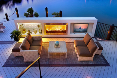 Photo of a large contemporary backyard patio in Miami with a fire feature, no cover and decking.