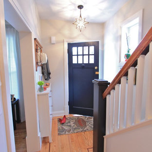 Bild på en liten eklektisk ingång och ytterdörr, med en blå dörr, grå väggar, ljust trägolv och en enkeldörr