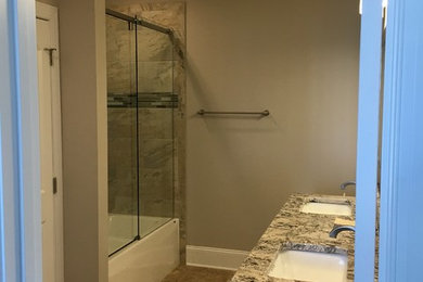 Mid-sized arts and crafts 3/4 beige tile and ceramic tile ceramic tile bathroom photo in Raleigh with raised-panel cabinets, white cabinets, beige walls, an undermount sink and granite countertops