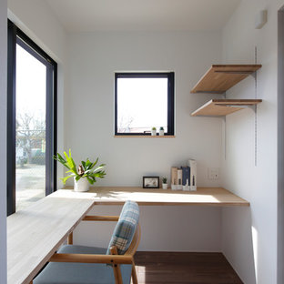 他の地域の小さいモダンスタイルのおしゃれなホームオフィス・仕事部屋 (白い壁、濃色無垢フローリング、造り付け机、茶色い床) の写真