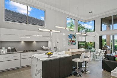 Example of a mid-sized minimalist l-shaped porcelain tile open concept kitchen design in Miami with a single-bowl sink, flat-panel cabinets, white cabinets, quartz countertops, gray backsplash, quartz backsplash, paneled appliances, an island and multicolored countertops