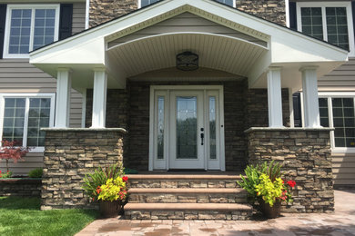 Large traditional beige two-story vinyl exterior home idea in New York with a shingle roof