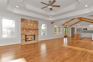 Inspiration for a mid-sized transitional formal and open concept medium tone wood floor and brown floor living room remodel in Birmingham with gray walls, a standard fireplace, a stone fireplace and no tv