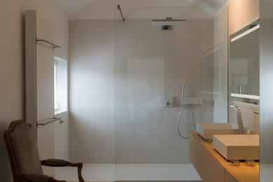 Réalisation d'une très grande salle de bain principale design en bois brun avec un placard à porte vitrée, une douche ouverte, un carrelage blanc, un mur beige, un sol en bois brun, un lavabo posé et un sol beige.