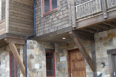 This is an example of a large country two-storey beige exterior in Denver with mixed siding.