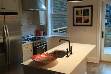 Example of a large minimalist eat-in kitchen design with shaker cabinets, white cabinets, quartz countertops, gray backsplash, stainless steel appliances, an island and white countertops