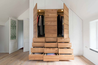 Photo of a large contemporary gender-neutral built-in wardrobe in Other with flat-panel cabinets, medium wood cabinets and medium hardwood floors.